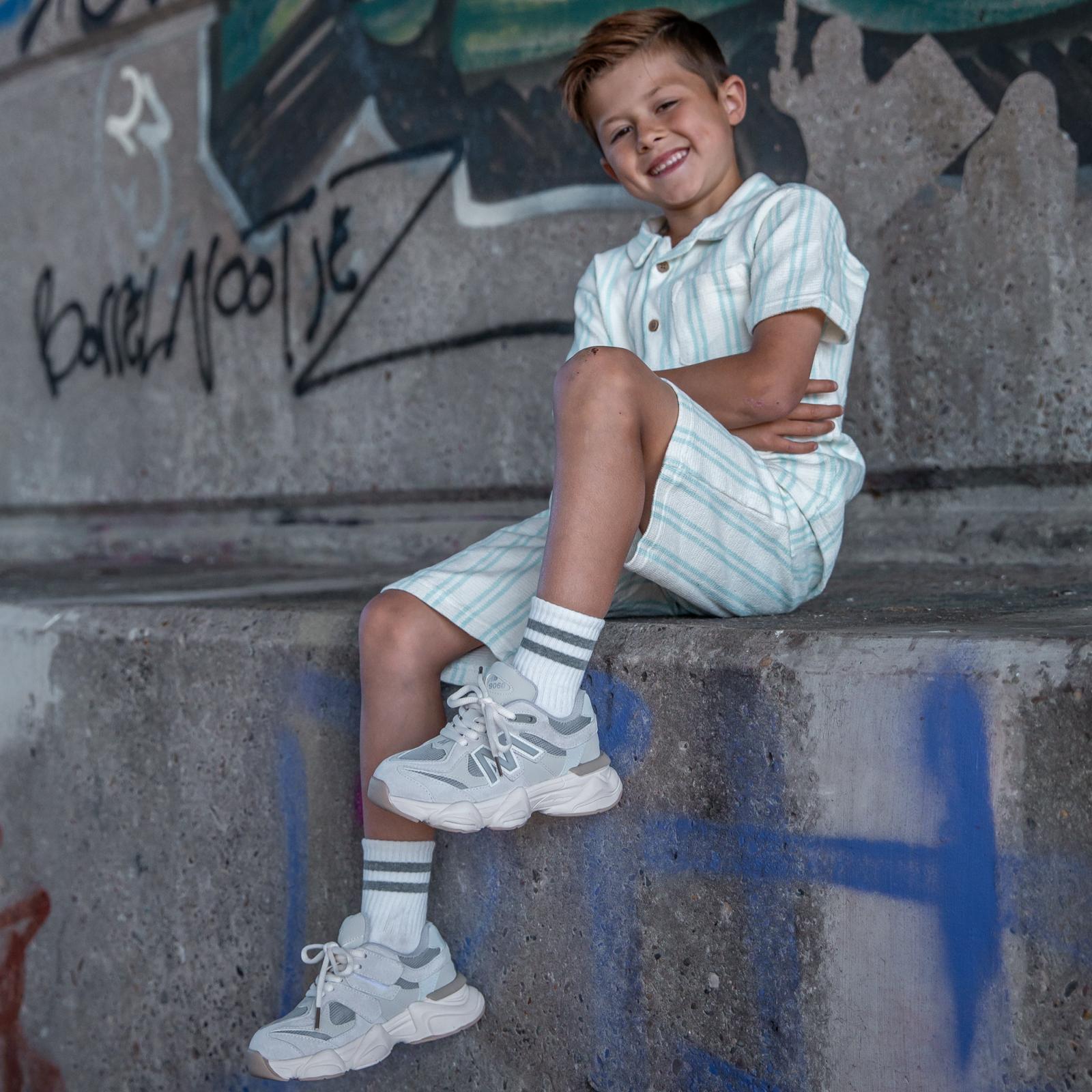 Beige Styloz Ivory kindersneakers gedragen door zittende jongen – trendy en comfortabele sneakers voor jongens van Lilpataz