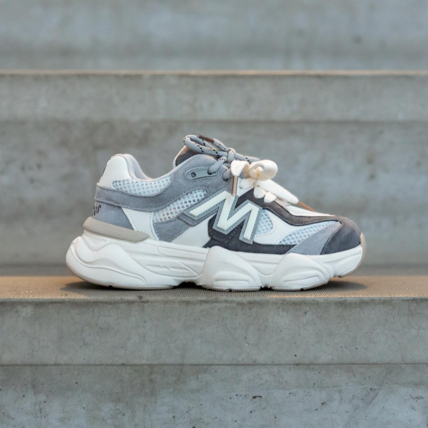 Zijaanzicht van de Styloz Moonstone Grey kindersneakers op betonnen trap